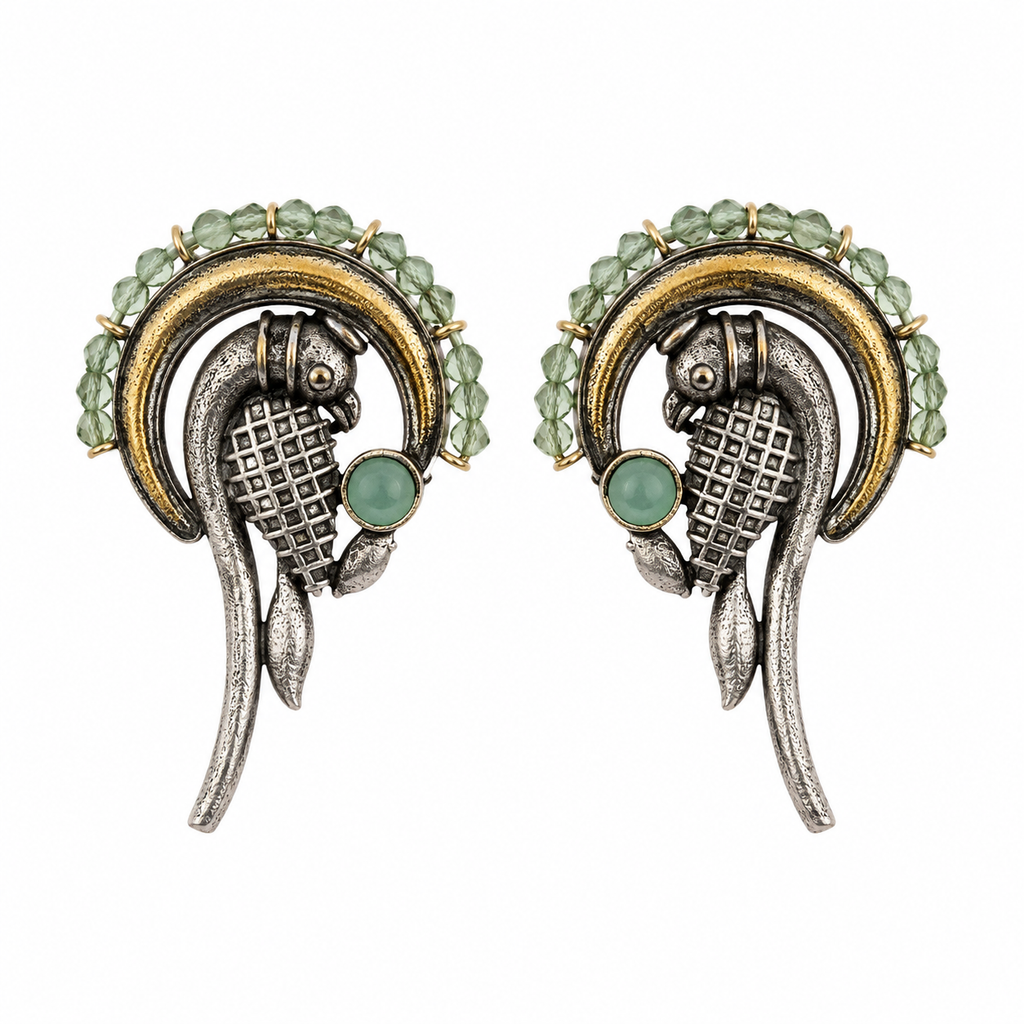A pair of vintage-style fish earrings featuring textured silver-toned metal, gold-toned accents, and light green faceted gemstones, set against a plain white background.